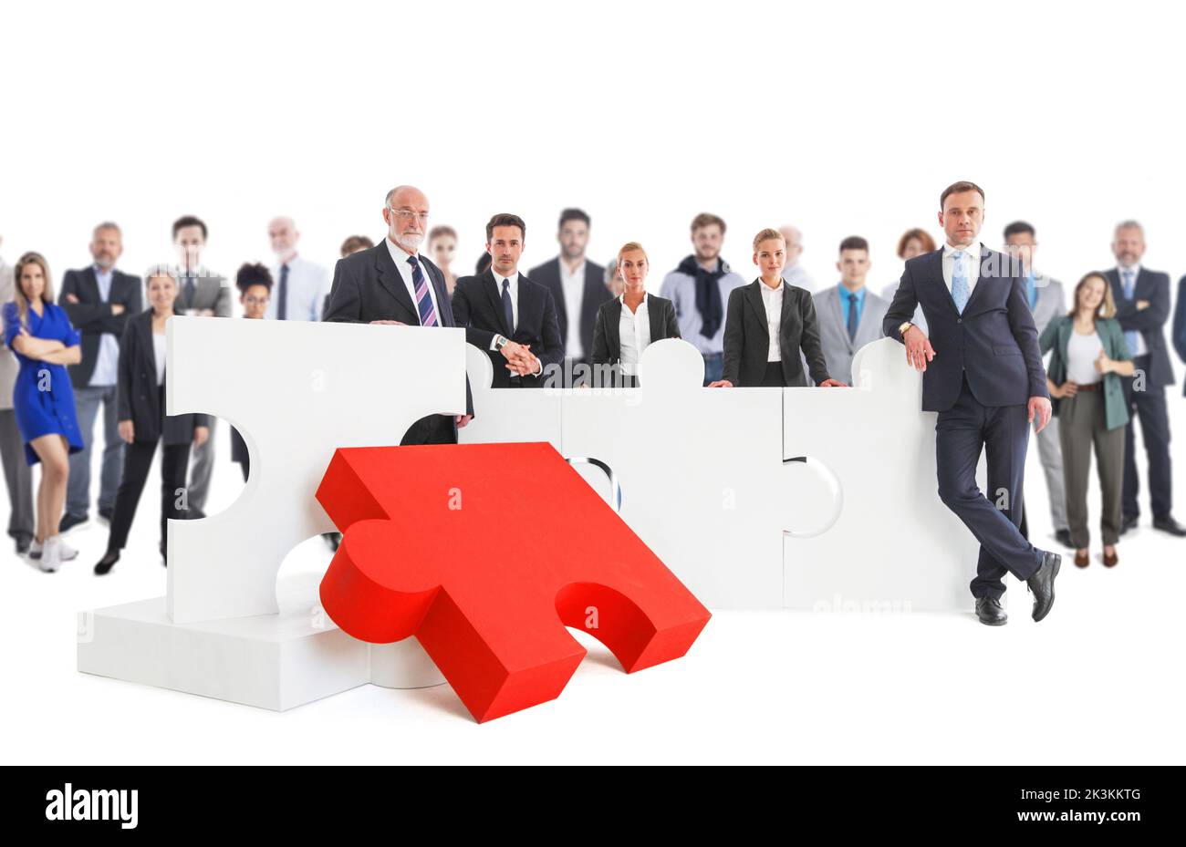 Business people team with giant puzzle pieces studio isolated on white background. Partnership teamwork cooperation collaboration concept. Stock Photo