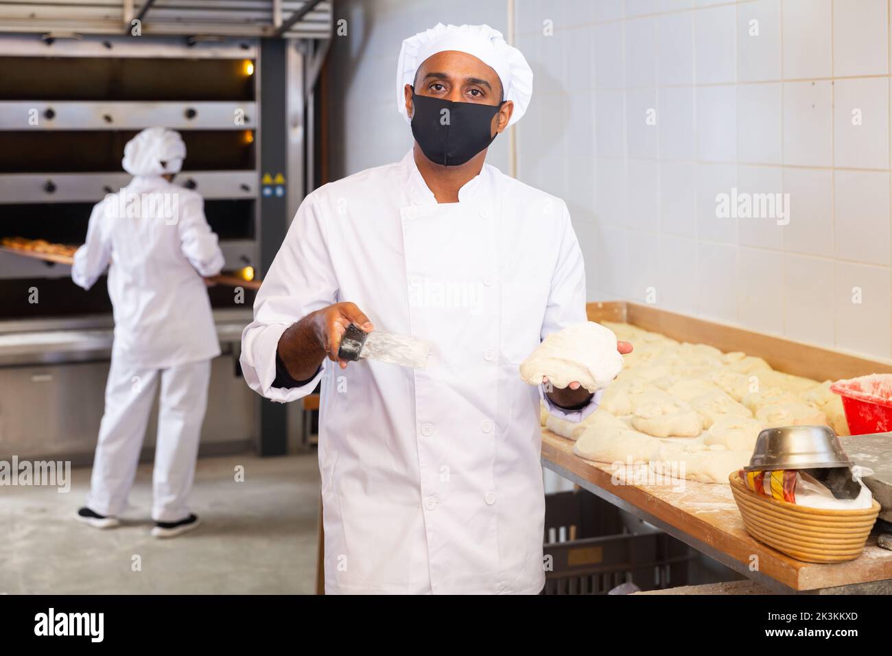 Baker dividing raw dough into equal parts in bakery Stock Photo Alamy