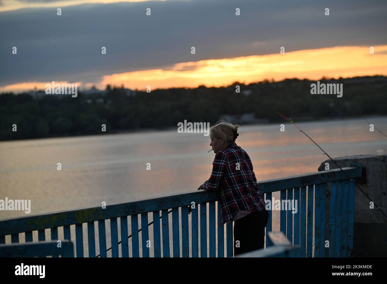 ZAPORIZHZHIA, UKRAINE - SEPTEMBER 1, 2022 - A woman smoking a cigarette fishes in Zaporizhzhia, southeastern Ukraine. Stock Photo