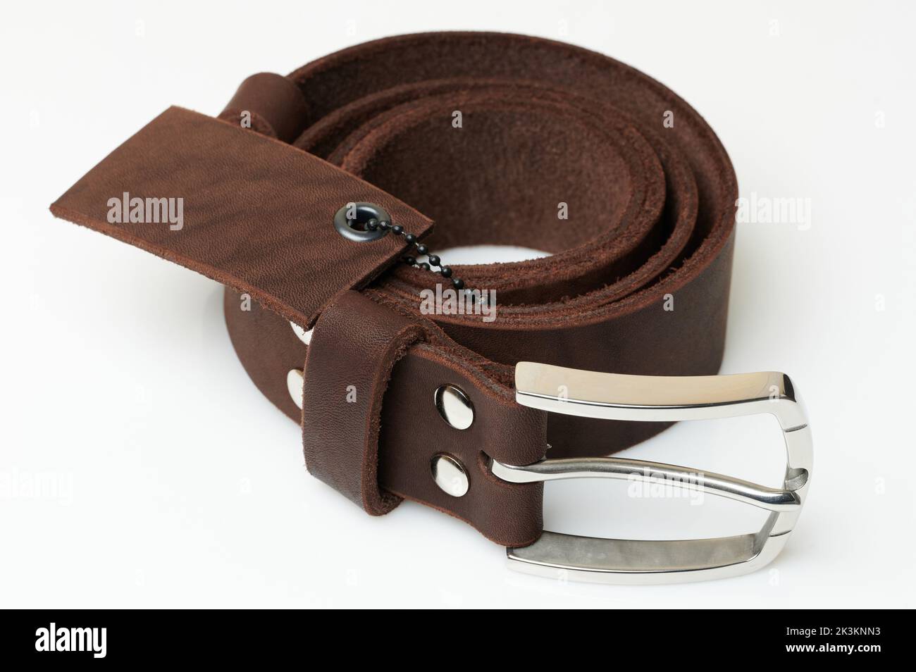 Brown color leather belt with metal buckle close up view isolated Stock Photo
