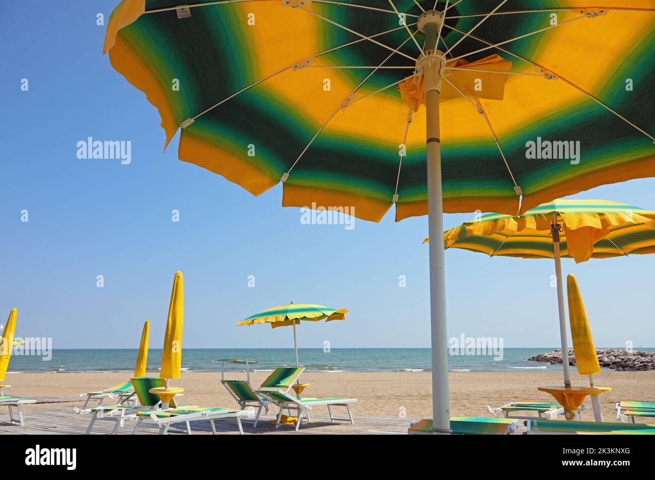 colored sun umbrellas on the sandy beach by the sea Stock Photo