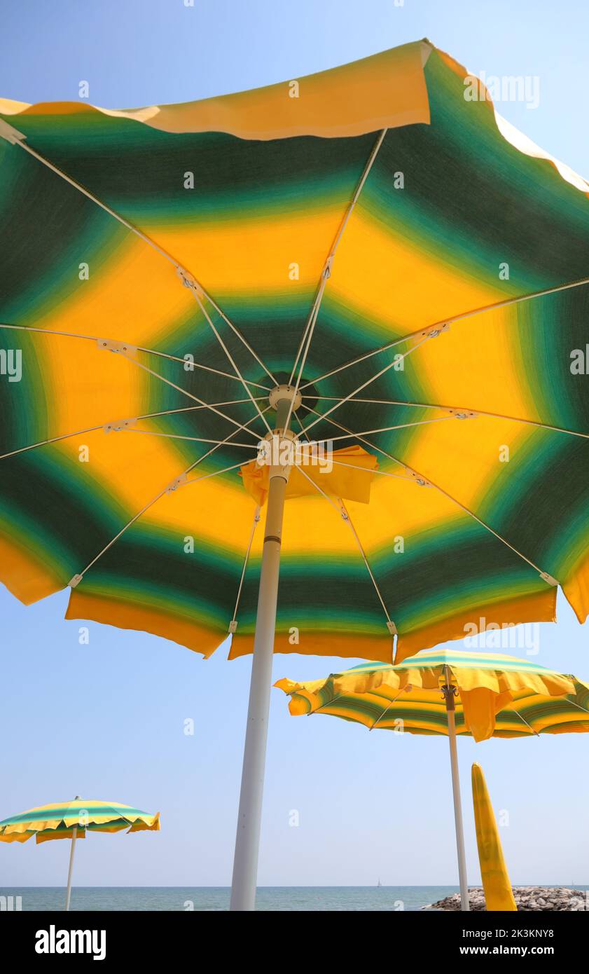 under a  sun umbrellas on the beach by the sea Stock Photo
