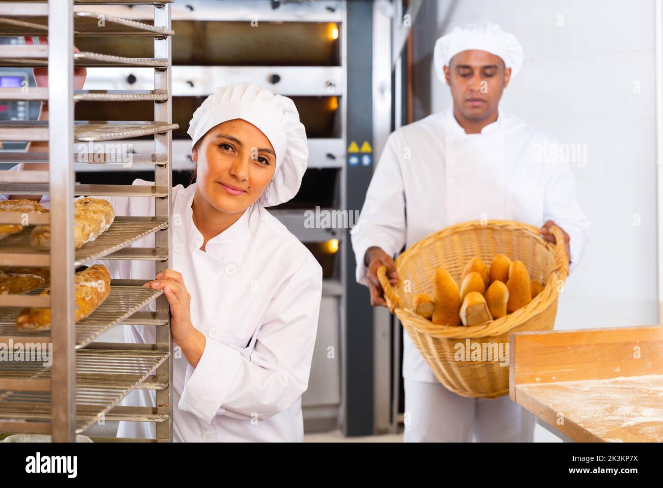 Woman transporting a cart with bread in bakery Stock Photo - Alamy