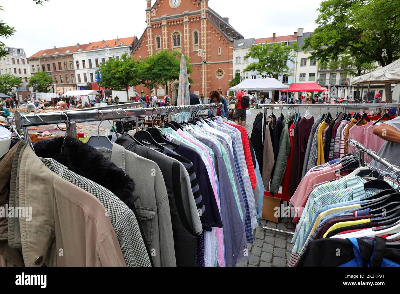 used clothes in the outdoor flea market stall with many bargains Stock Photo