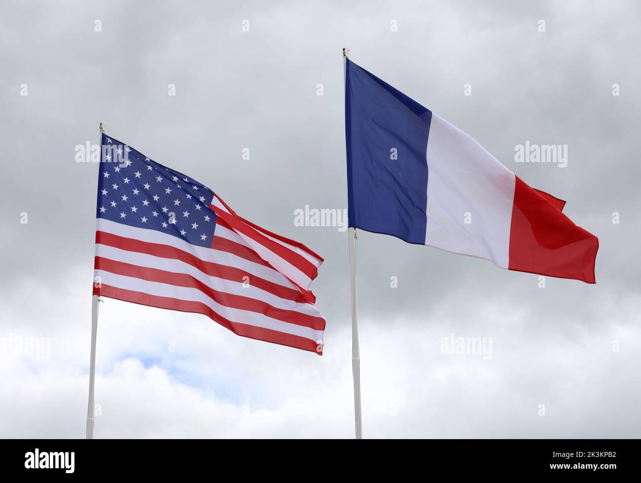 large American and French flags with blue sky background waving together Stock Photo