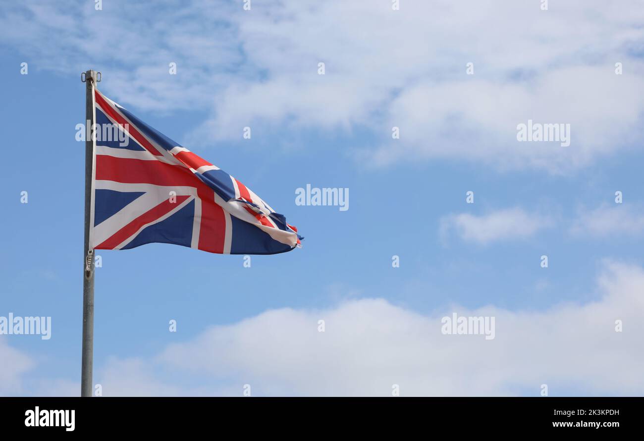 united kingdom flag on the blue sky and some white clouds Stock Photo