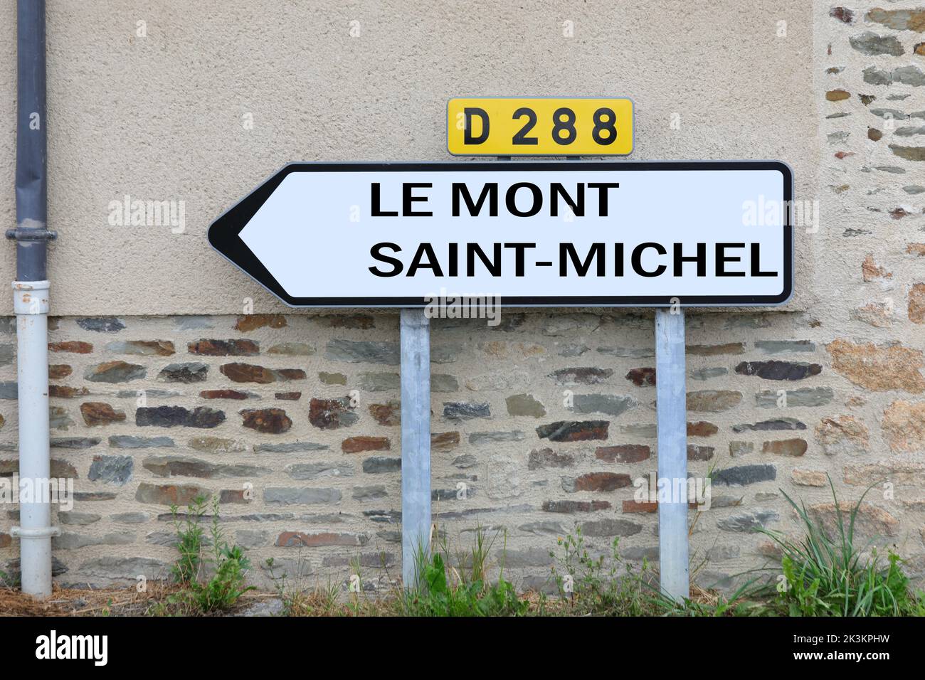 road sign with the text Le Mont ST Michel and the arrow to reach the Normadian abbey in France Stock Photo