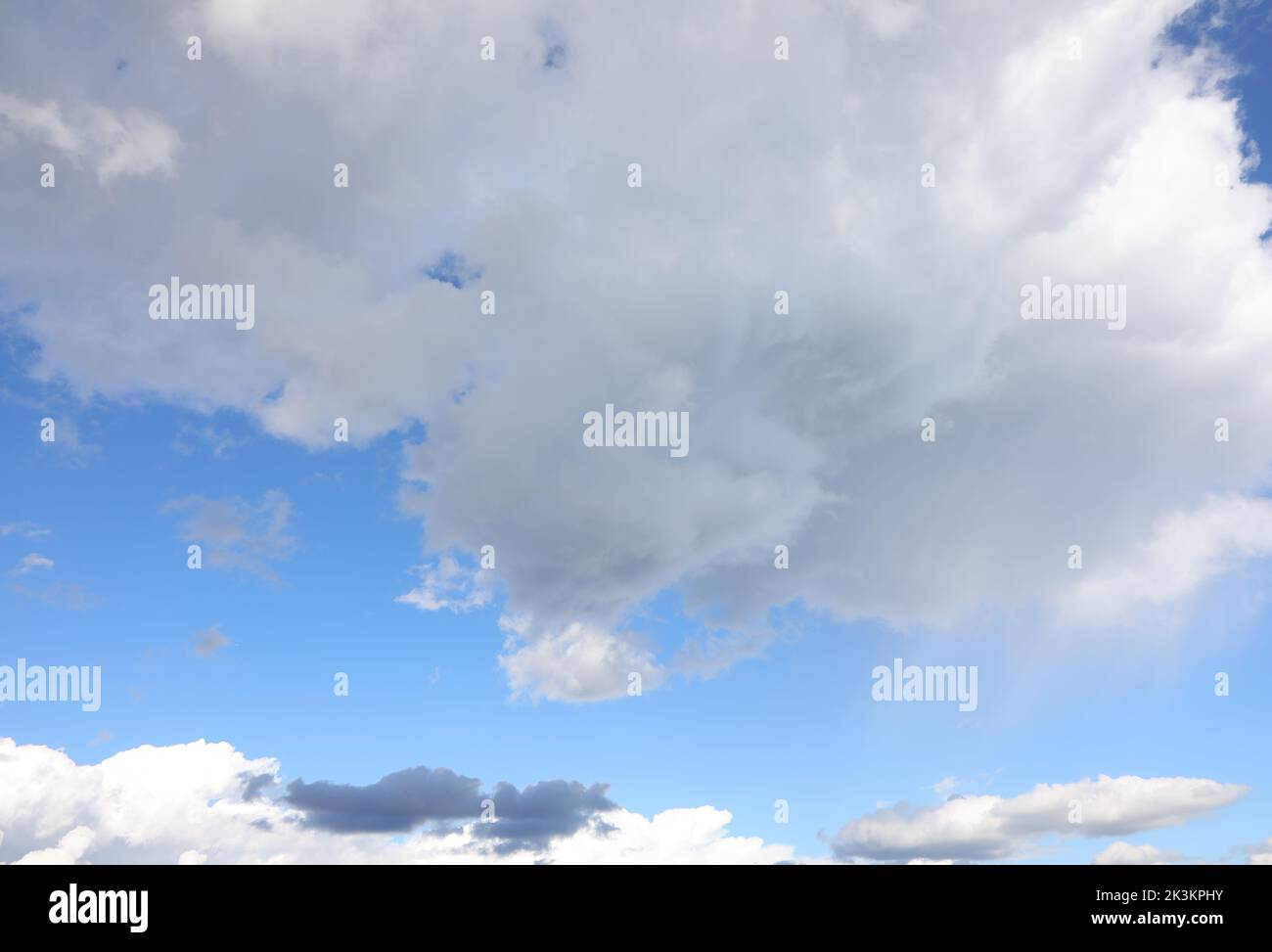 clear blue sky with white clouds and some black clouds without planes Stock Photo