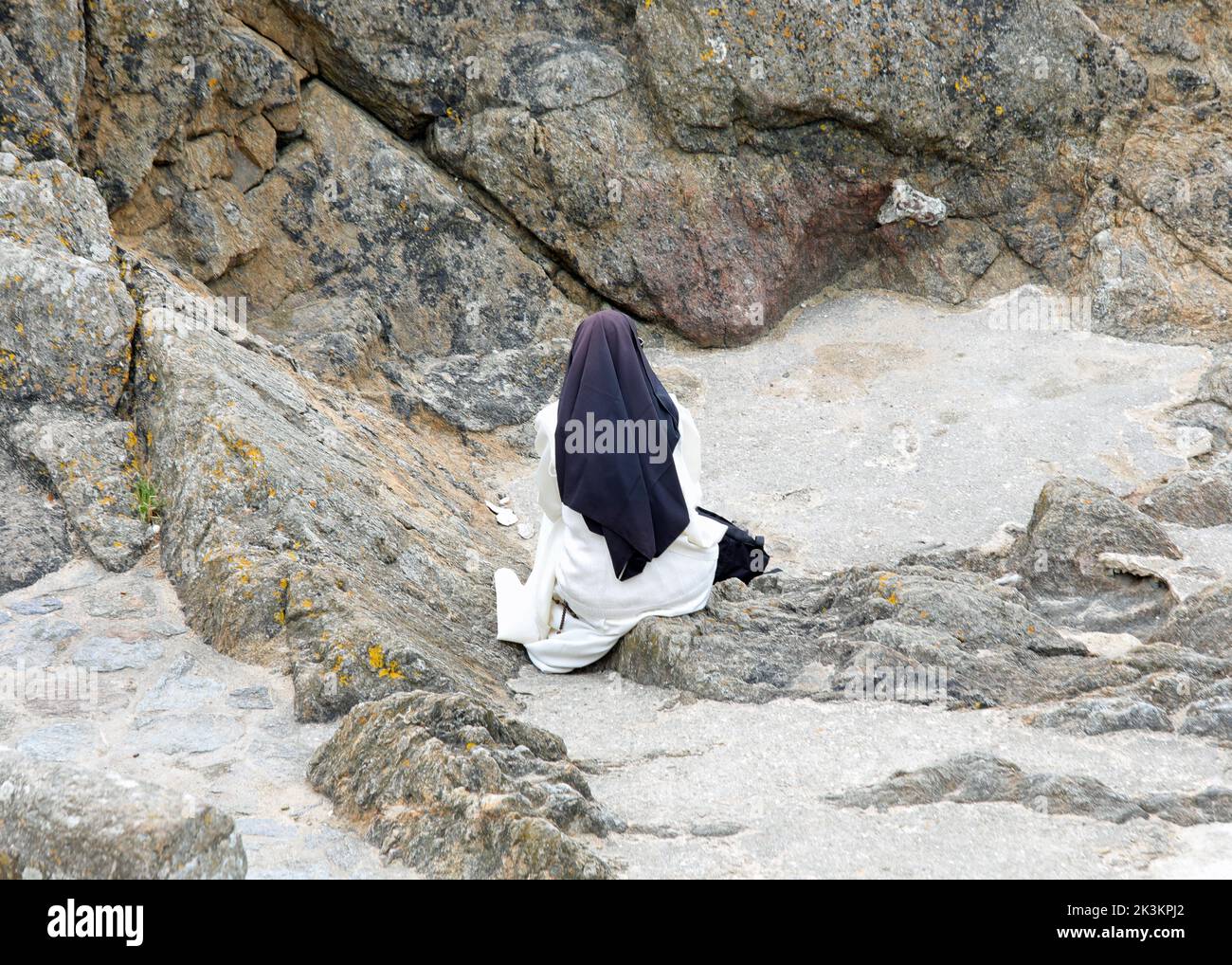 Solitary nun in prayer dressed in a monastic habit and a black veil on her head Stock Photo