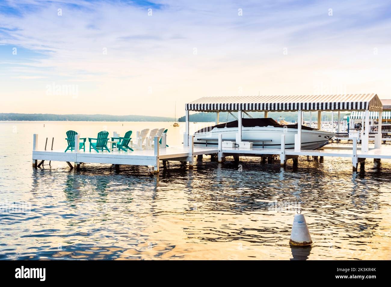 Small wooden pier with private yacht, early morning at Lake Geneva, Wisconsin, America. Stock Photo