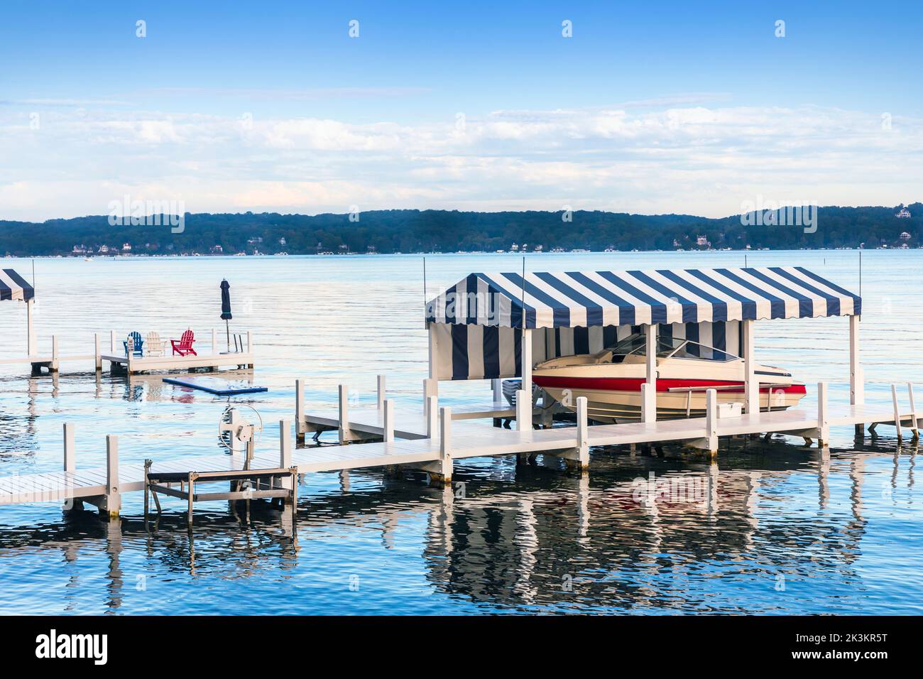 Small wooden pier with private boat, early morning at Lake Geneva, Wisconsin, America. Stock Photo