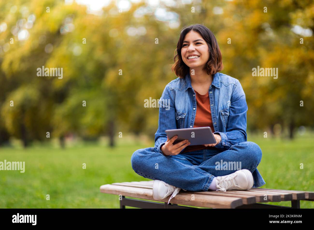 Happy Beautiful Young Arab Woman Relaxing With Digital Tablet Outdoors Stock Photo