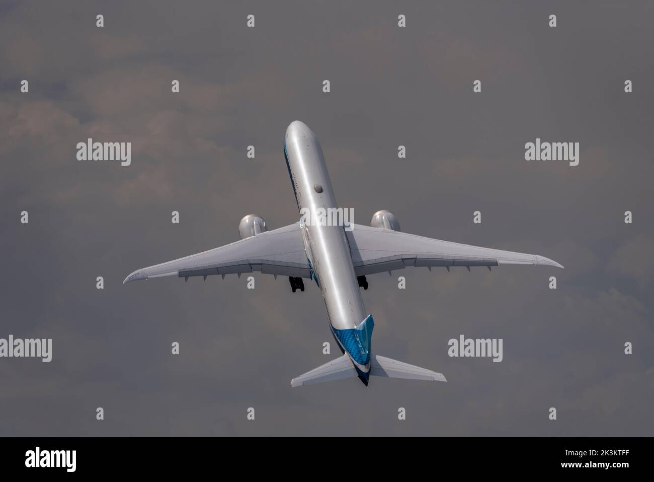 Boeing 777-9, also known as 777X, airliner jet plane at Farnborough International Airshow 2022, steep climb after take off into darkening sky Stock Photo