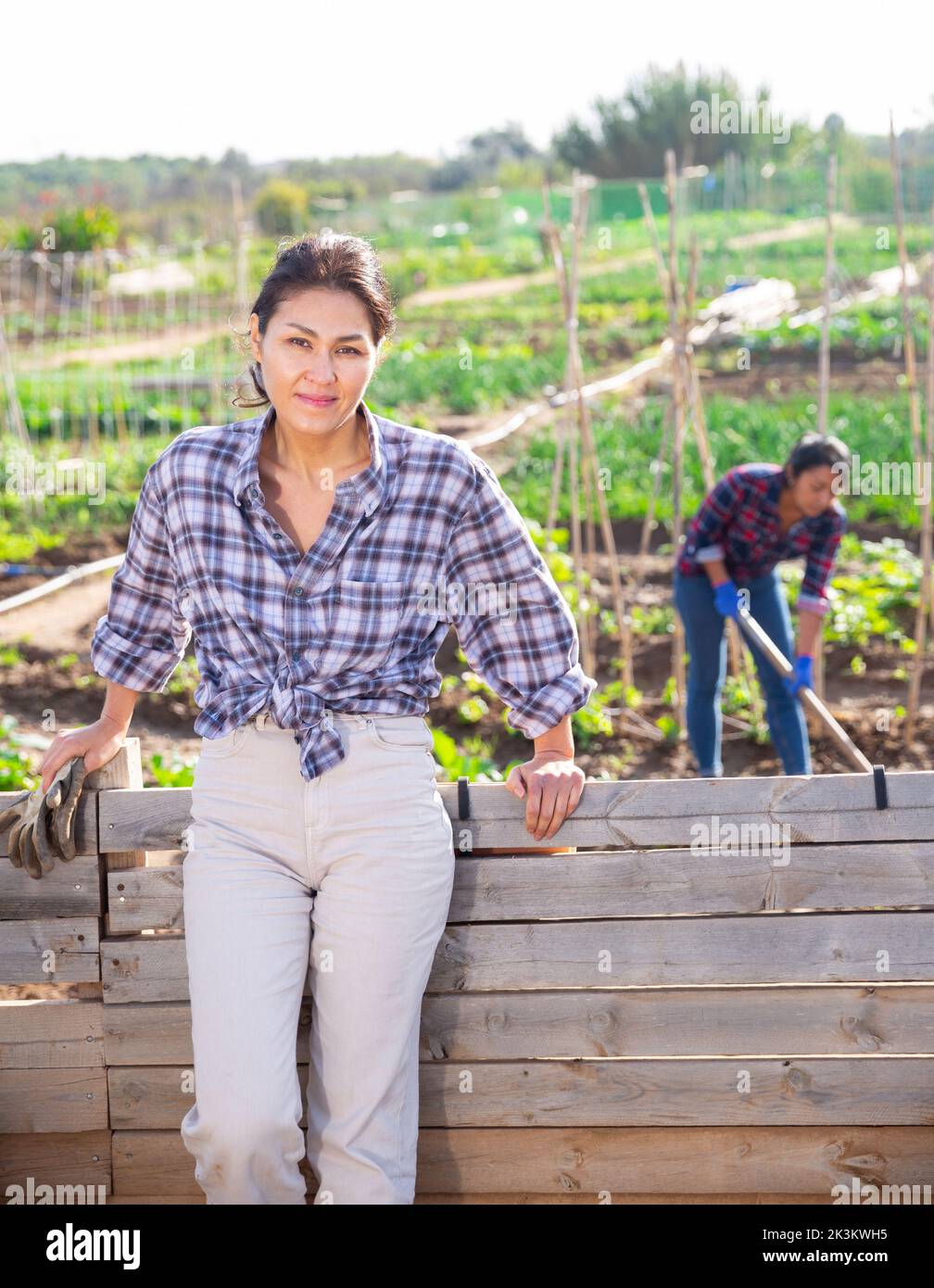 Female gardener posing with a shovel in garden Stock Photo - Alamy