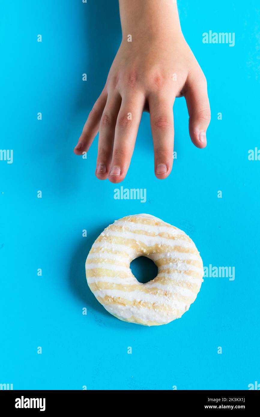 Donut with hazelnuts on blue background, close up Stock Photo