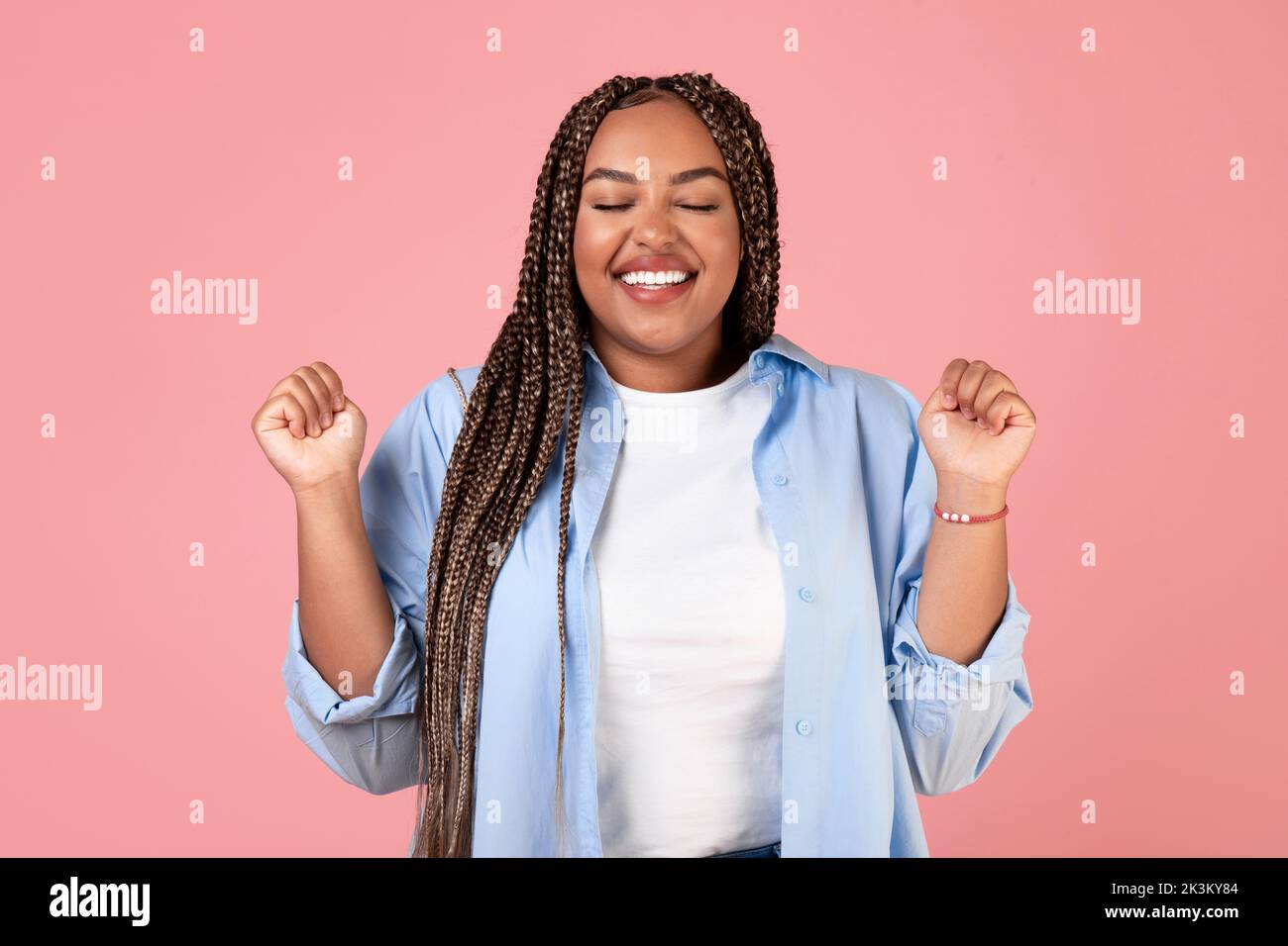 African Lady Shaking Fists Posing With Eyes Closed, Pink Background Stock Photo Alamy