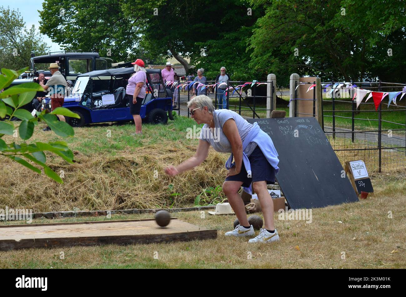 Lady playing skittles at Warmwell summer fete in Dorset, UK Stock Photo