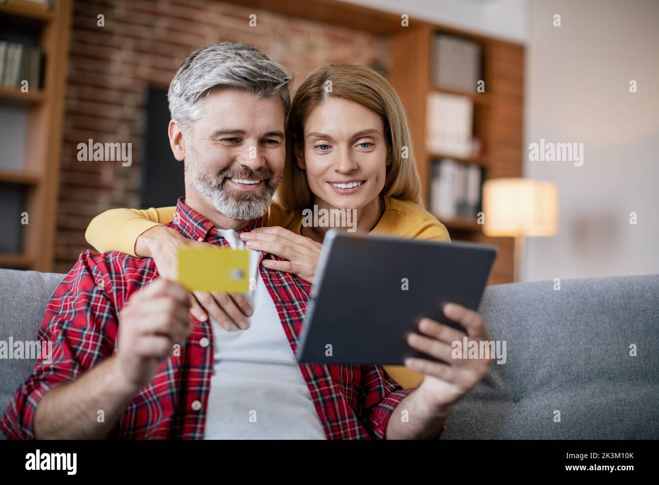 Huge sale for shopaholic. Smiling mature european female hugs husband ...