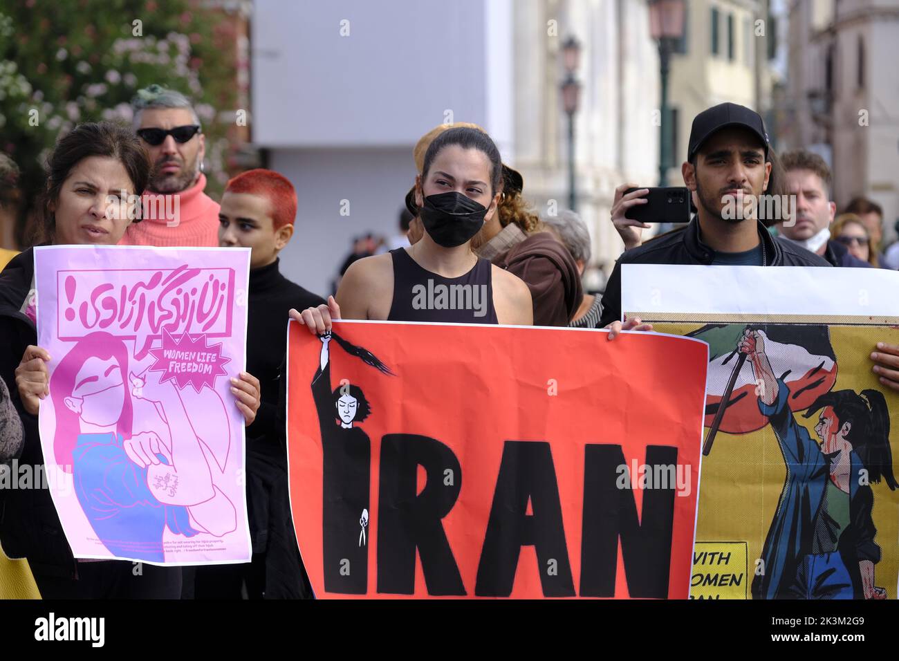 Iranian girls protest in front of Venice train station displaying a sign reading 'Woman Freedom Life' on September 27, 2022 in Venice, Italy. Stock Photo