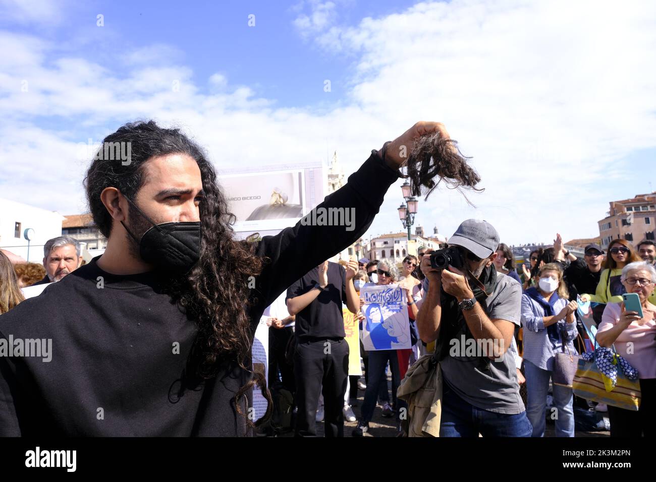 Iranian girls protest in front of Venice train station displaying a sign reading 'Woman Freedom Life' on September 27, 2022 in Venice, Italy. Stock Photo