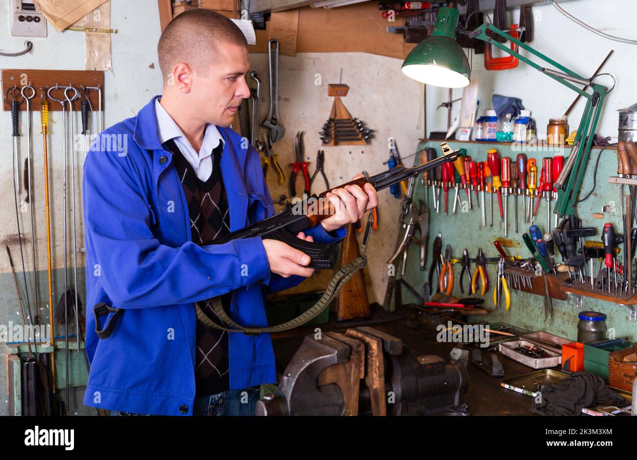 Gunsmith performing maintenance of Kalashnikov assault rifle in
