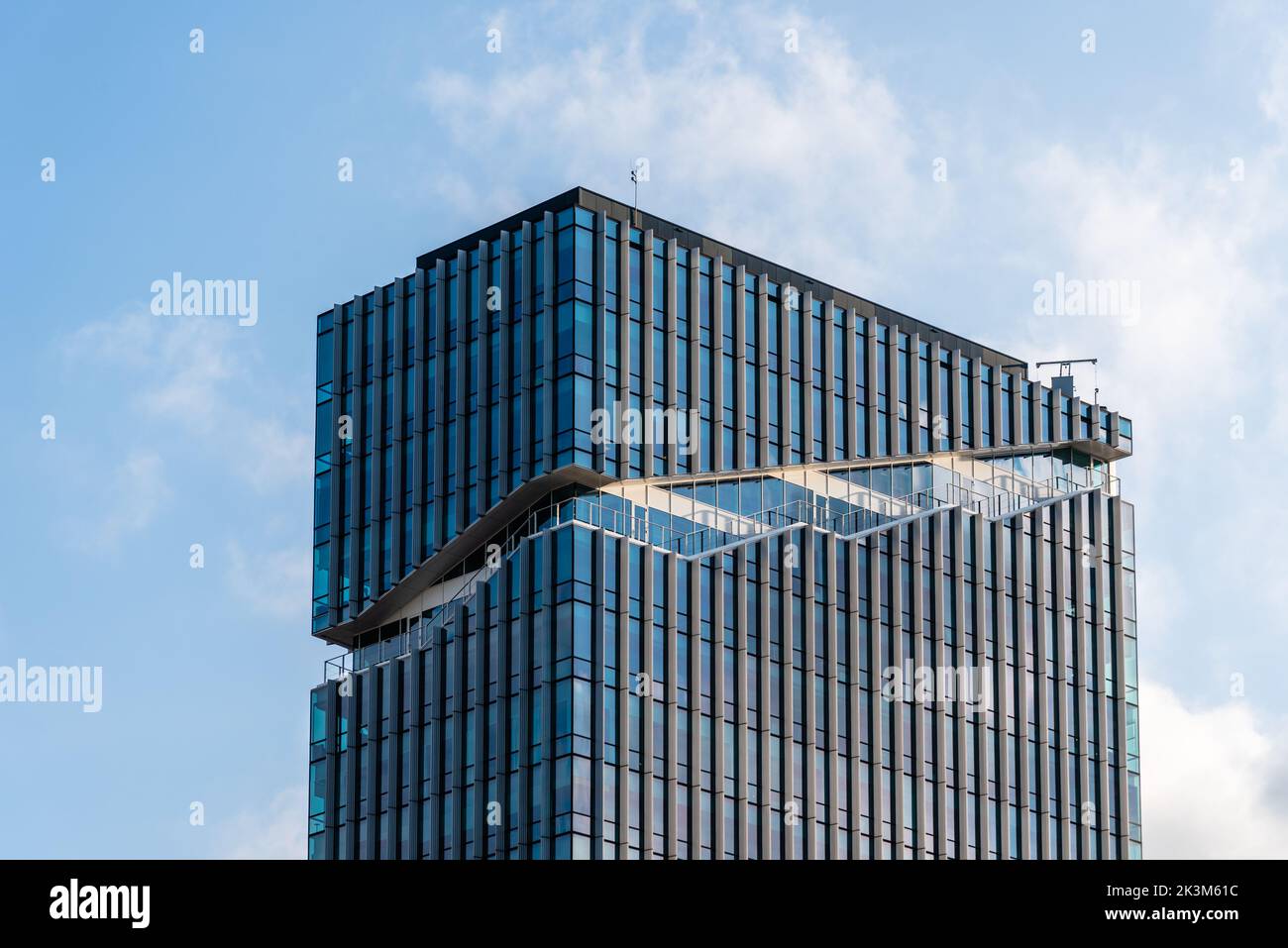 Amsterdam, Netherlands - May 7, 2022: Low angle view of futuristic architecture skyscraper against sky. Contemporary architecture, blue colors. Low an Stock Photo