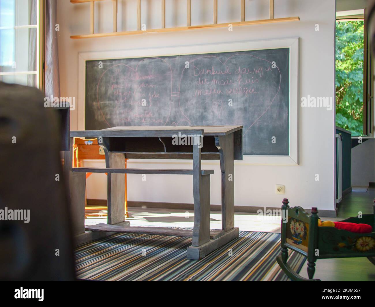 A classroom with a desk, a slate chalkboard to write with chalk Stock Photo