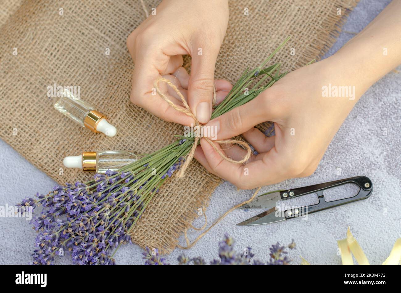 Step by step photo of a woman's hands tying a bouquet of lavender with