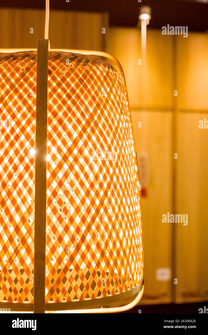 Wicker lamp hanging from the ceiling gray background.Texture of rattan