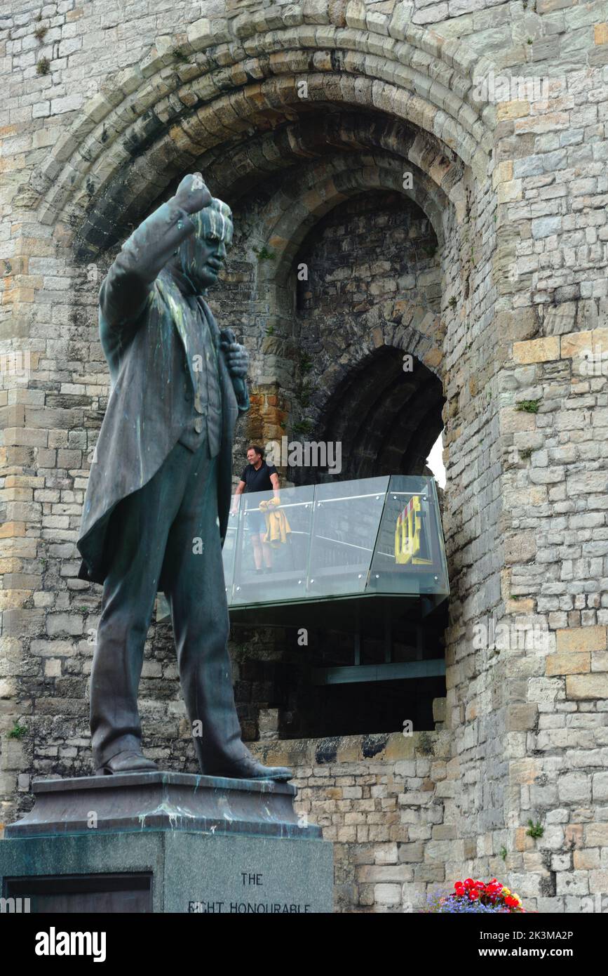 Statue of David LLoyd George, former PM of Britain, with the Queen's gate of Caernarfon Castle in the background. Stock Photo