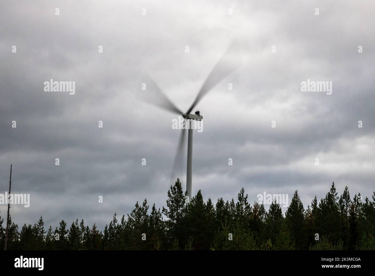 Spinning wind turbine against the cloudy sky, long exposure shot in Otanmäki, Finland Stock Photo