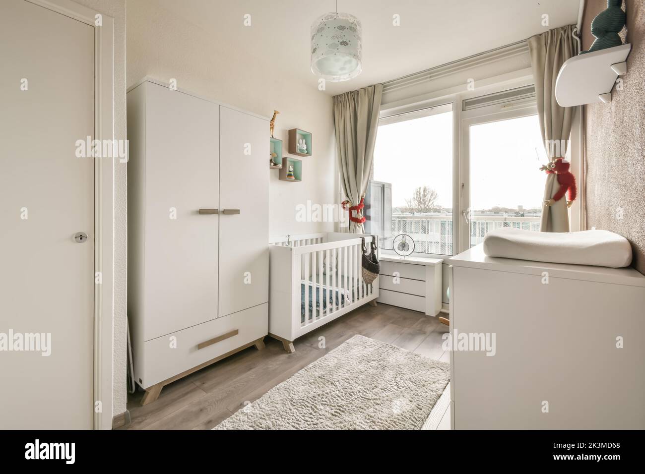 Small wooden baby cot placed near window in bedroom with minimalistic