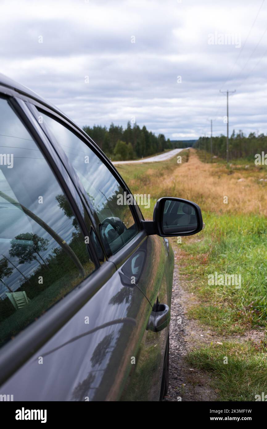 Closeup side view from the passenger side of a car parked next to a road in the countryside Stock Photo