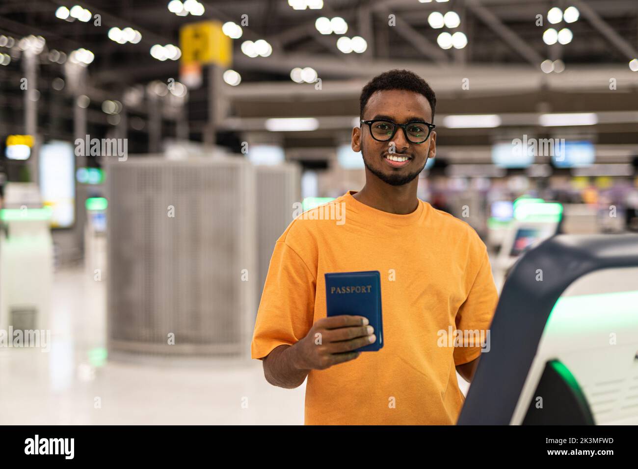 Young handsome black man ready to travel at airport terminal waiting for flight Stock Photo