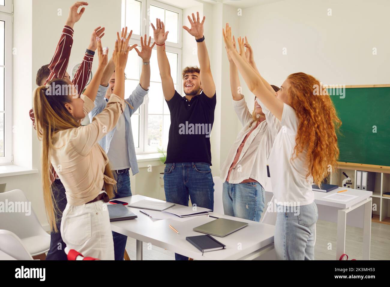 Group of happy school students enjoying teamwork and having fun in the classroom Stock Photo