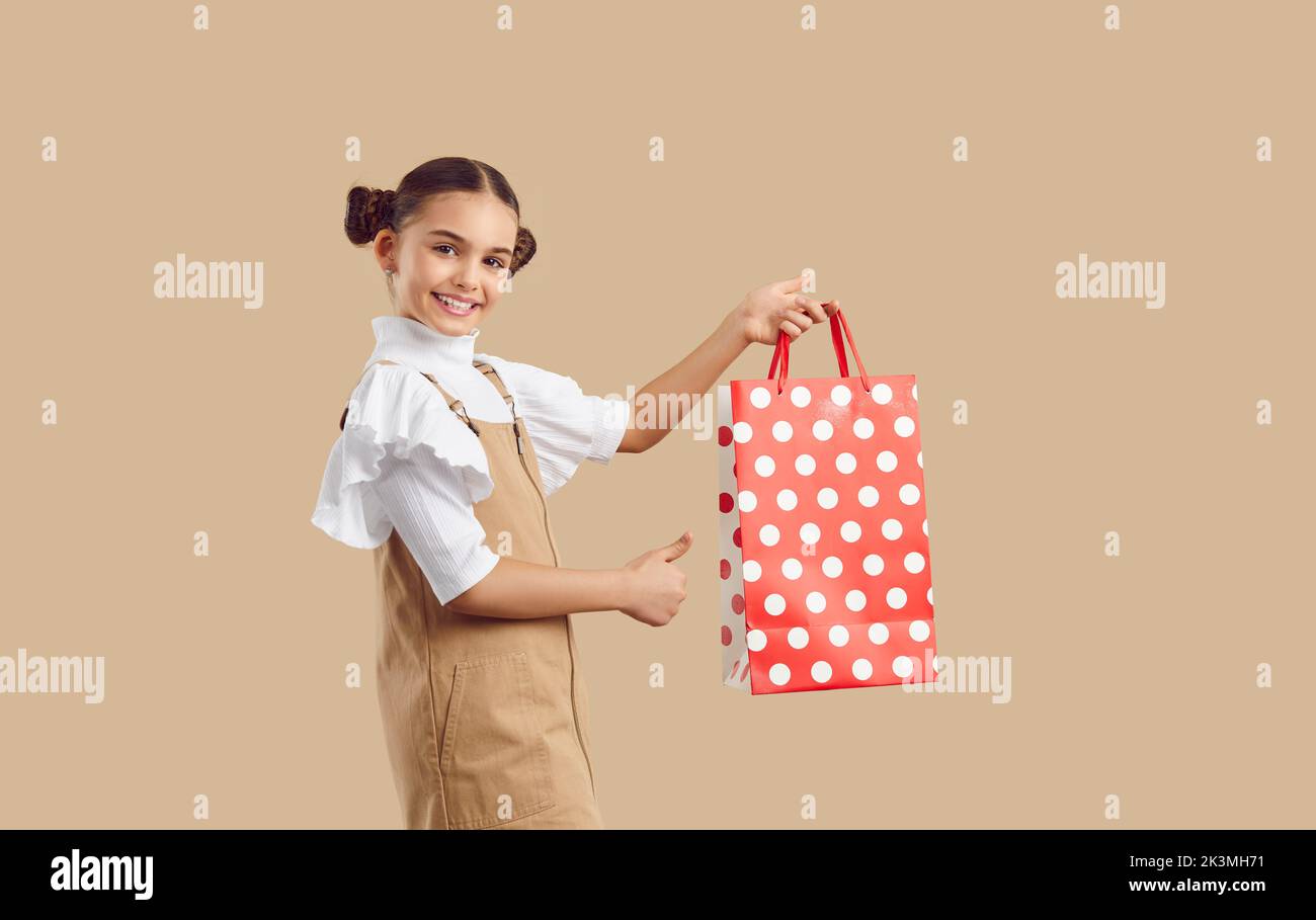 Beautiful cute happy preteen game with shopping package recommends shopping discounts. Stock Photo