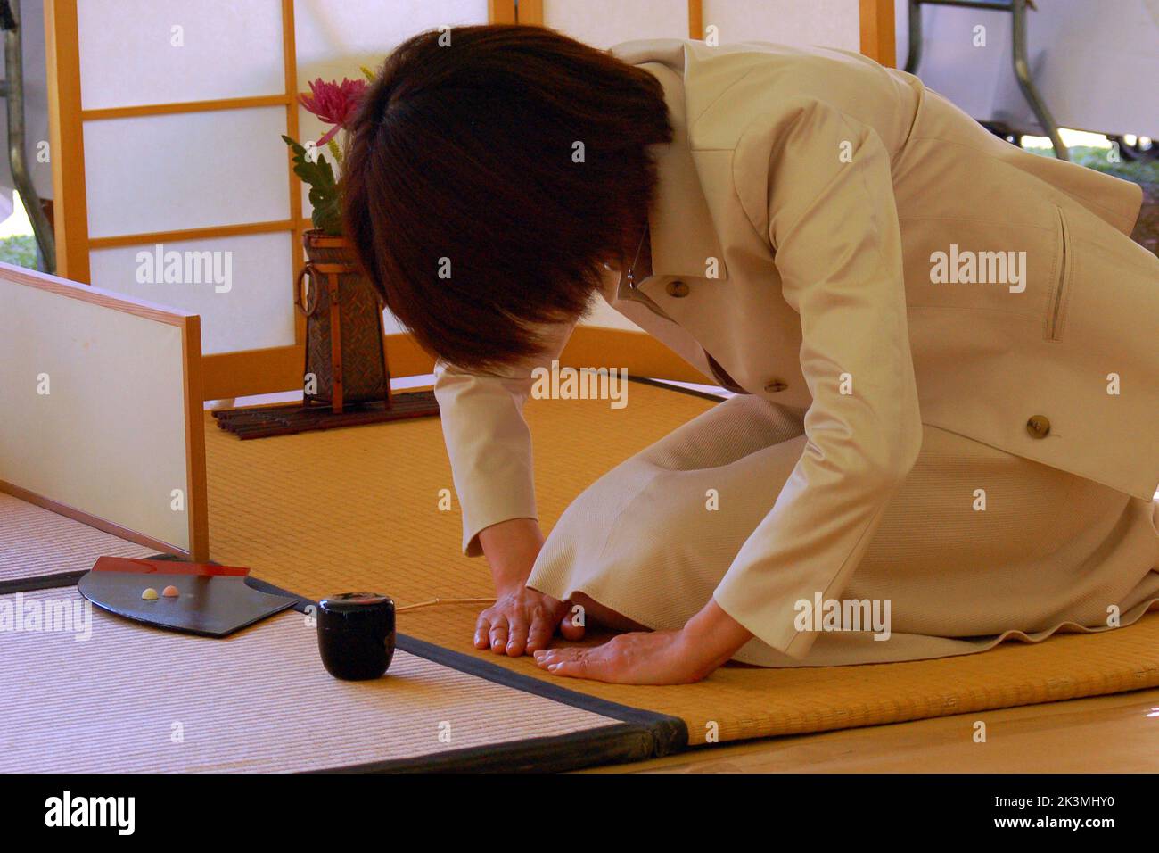 A young woman bows at the beginning of a solemn Japanese Tea Ceremony demonstration, a tradition in Japan Stock Photo