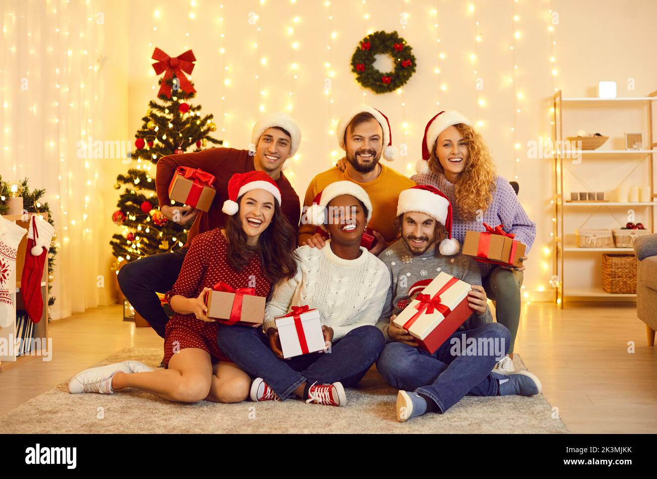 Group portrait of happy young friends who celebrate New Year holidays together at home. Stock Photo