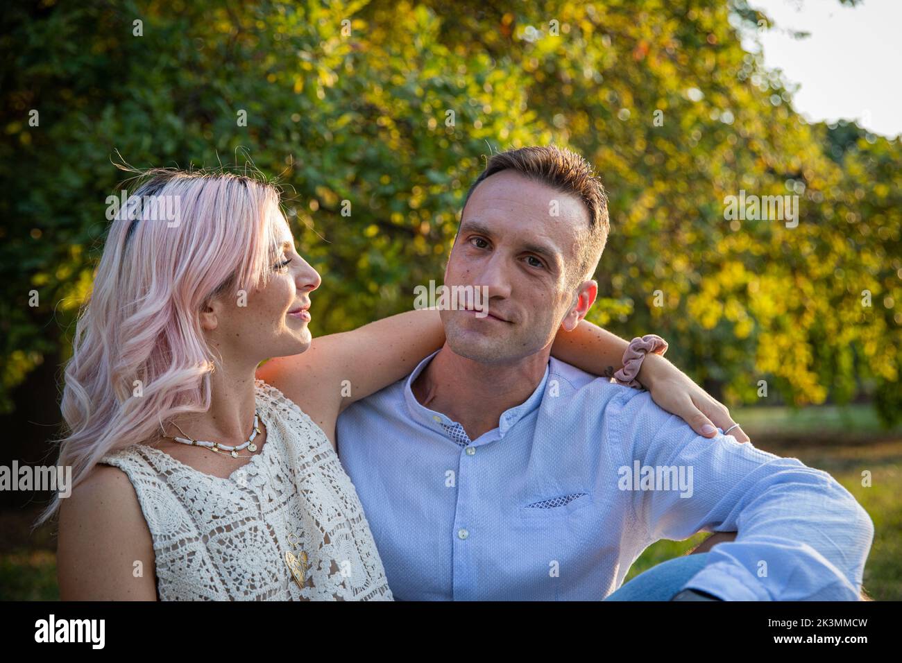 Beautiful loving couple embraced stand still during a walk in the park. Stock Photo