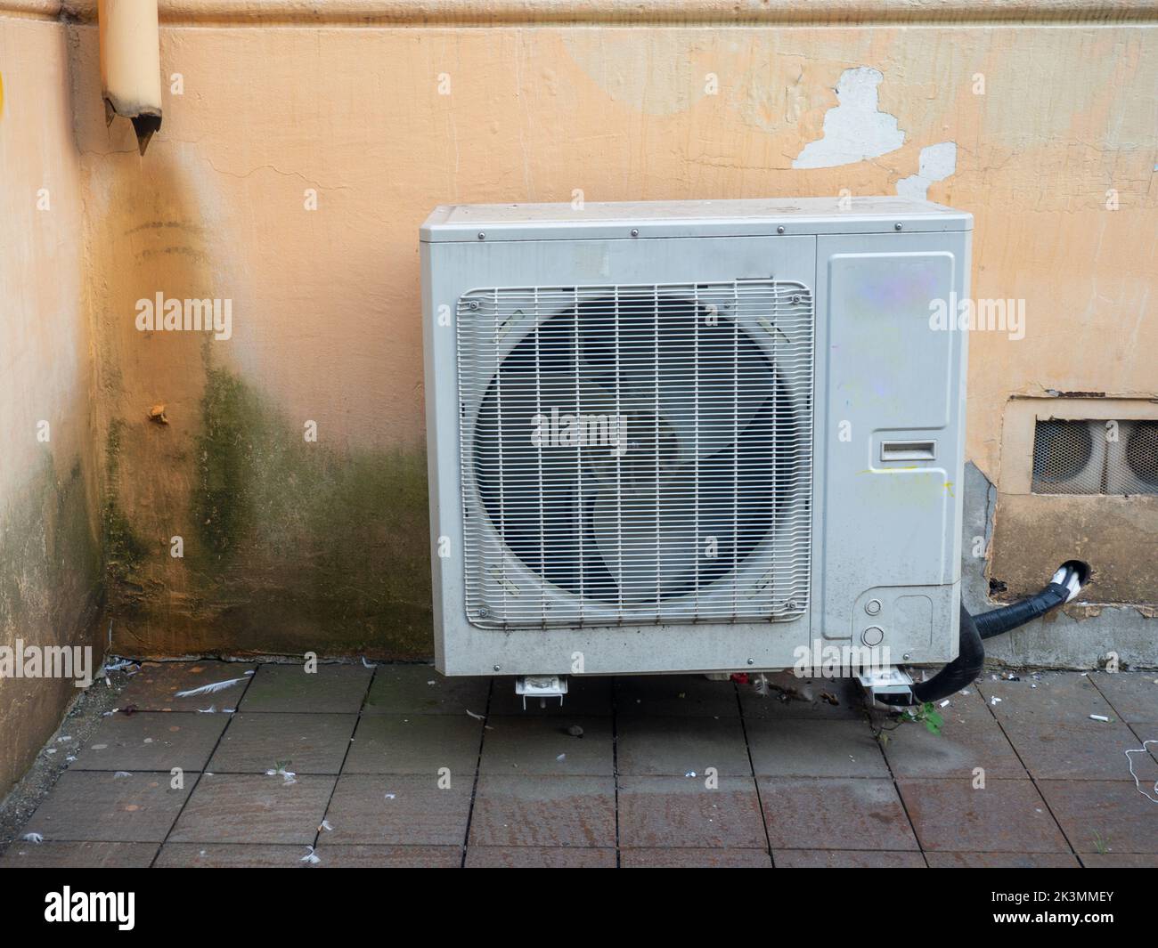 Old air conditioner on the corner of the house. Air conditioning among on the wall in a dirty