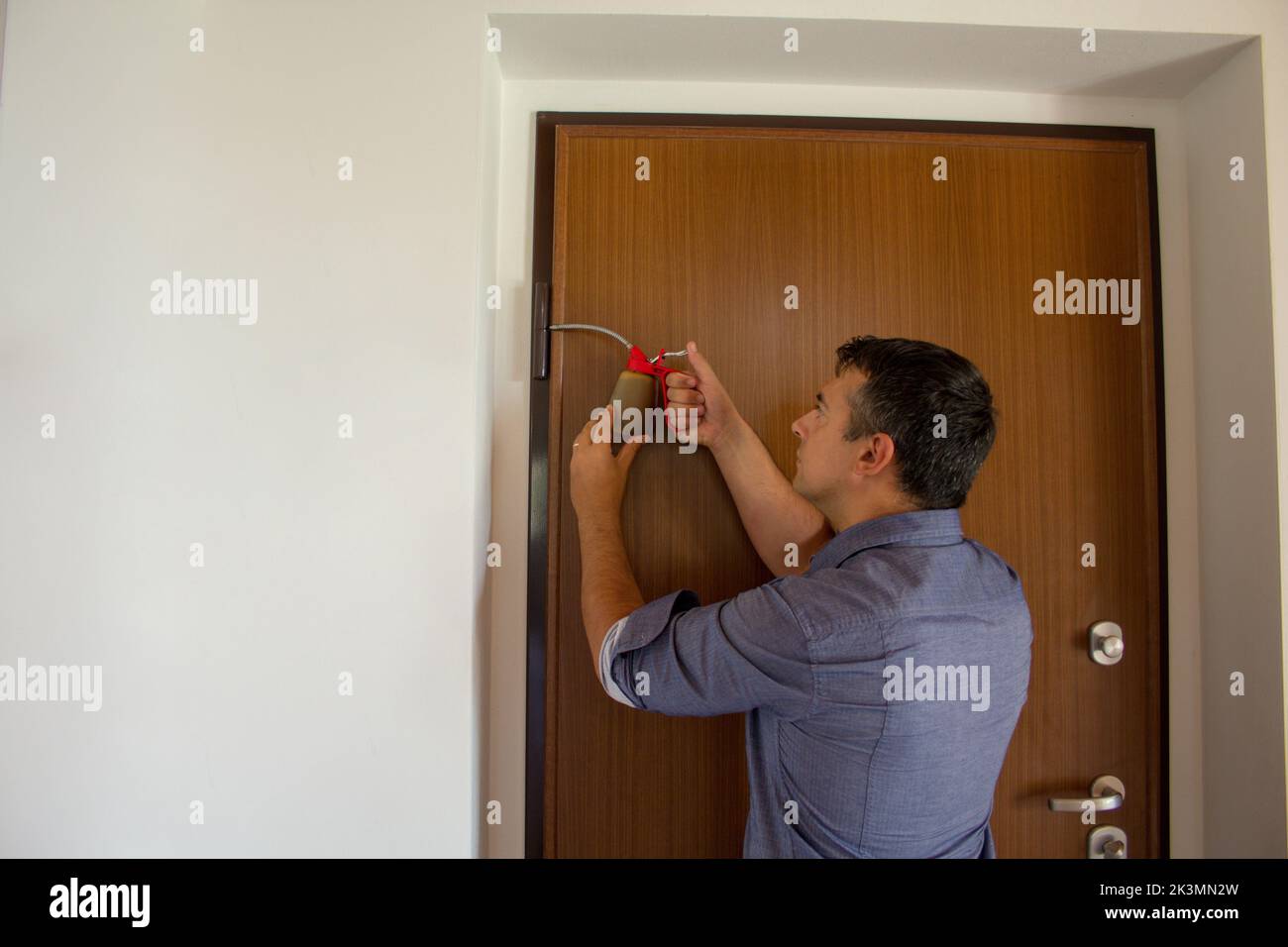 Picture of a handyman who with an oiler lubricates the hinges of a