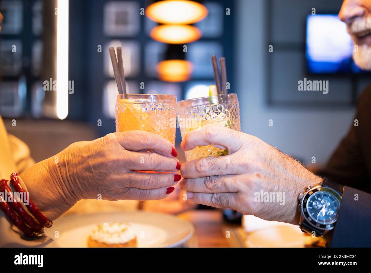 Two older people celebrating and toasting at the bar Stock Photo
