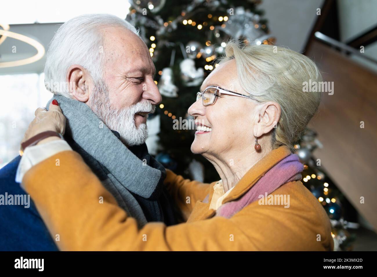 Close up of an elderly couple falling in love again by the Christmas tree Stock Photo