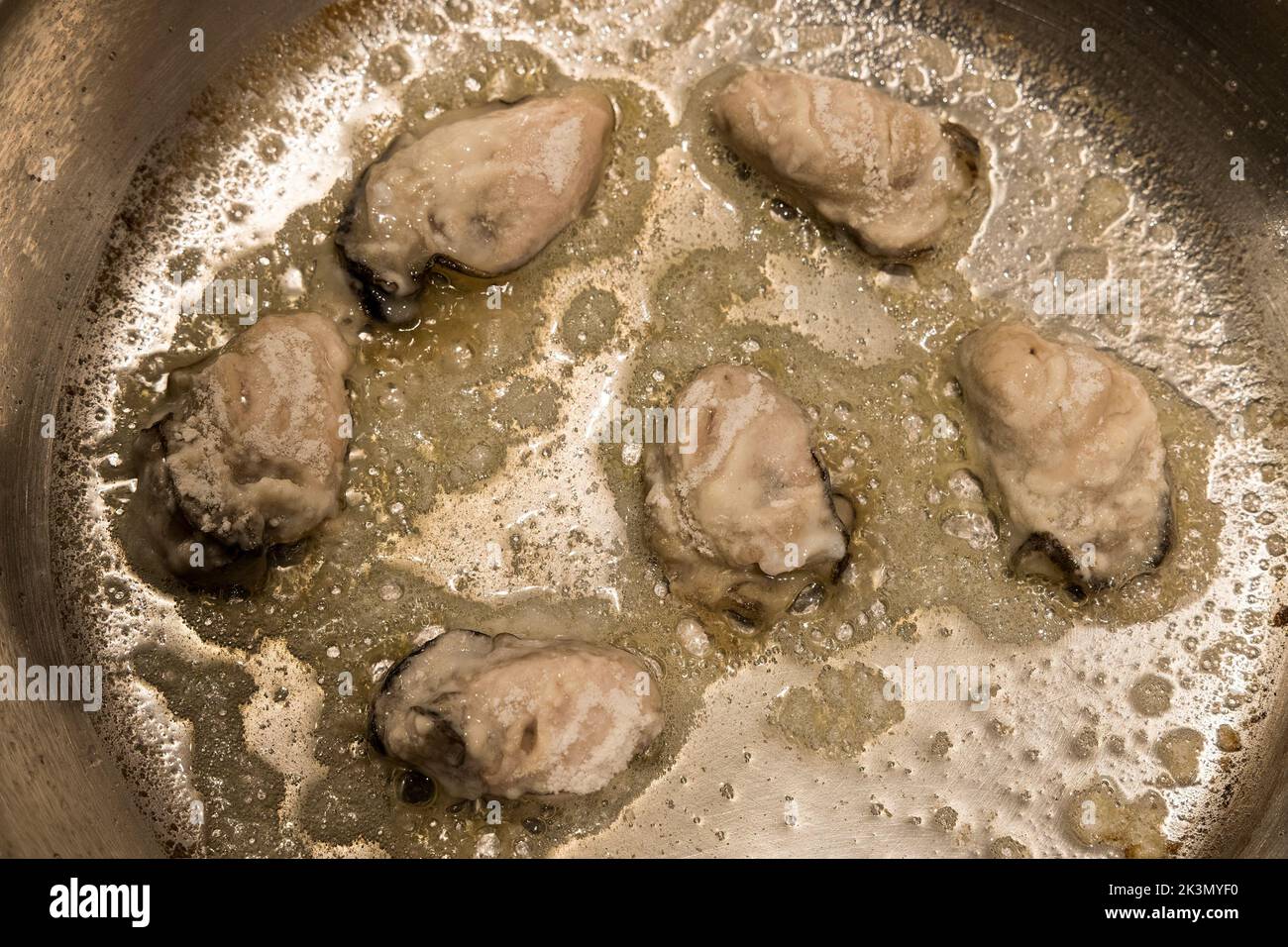 Oysters frying in butter, UK Stock Photo