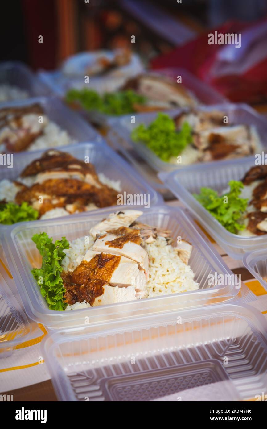 Typical Malaysian daily food at street stall or bazaar, Chicken Rice packed in bio degradable plastic container . Stock Photo