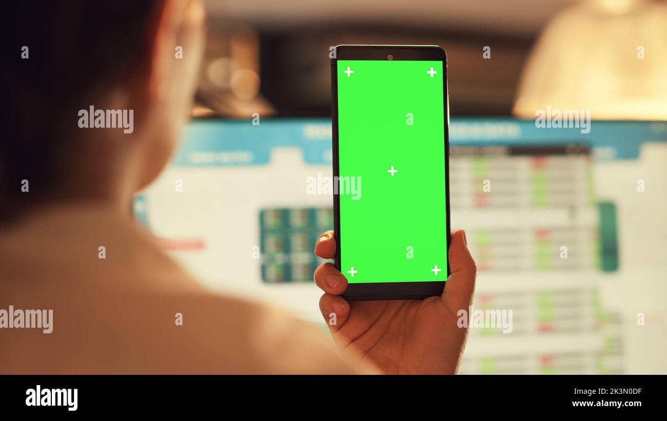 Female manager using smartphone with greenscreen display, analyzing ...