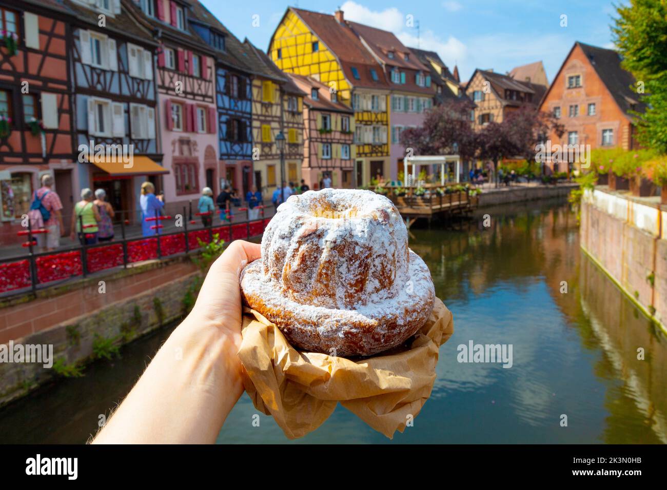 Kougelhopf cake from Marché couvert with Little Venice in the background, Colmar, France Stock Photo