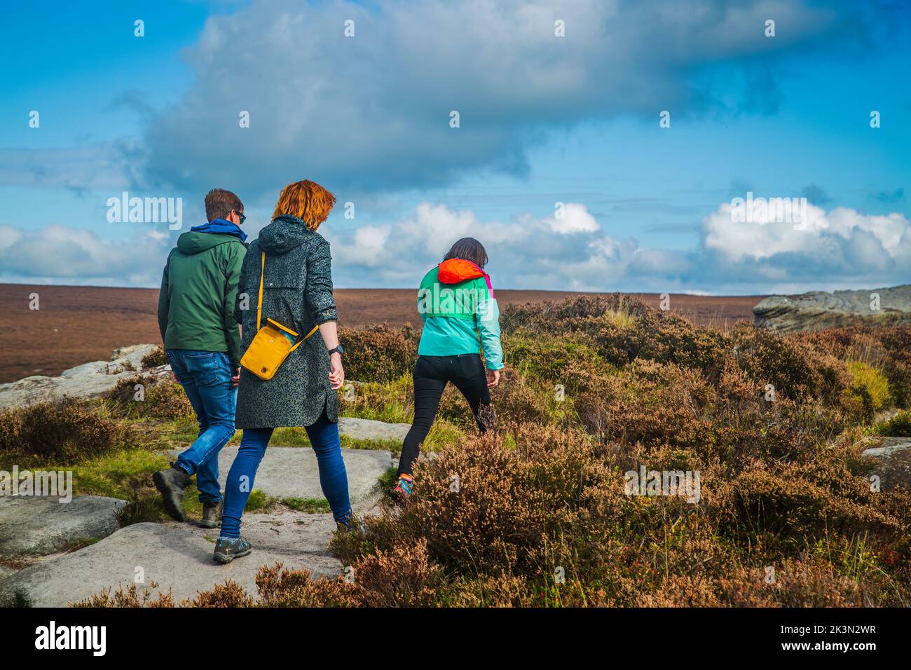 24.09.2022 Burbage, Sheffield, Female hill walkers in outdoor clothing stridding across gritstone moors in the Peak district Stock Photo
