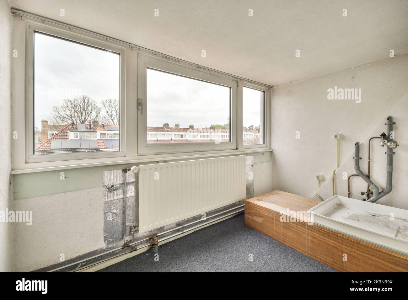 Flush toilet located between sink and shower in small tiled bathroom of