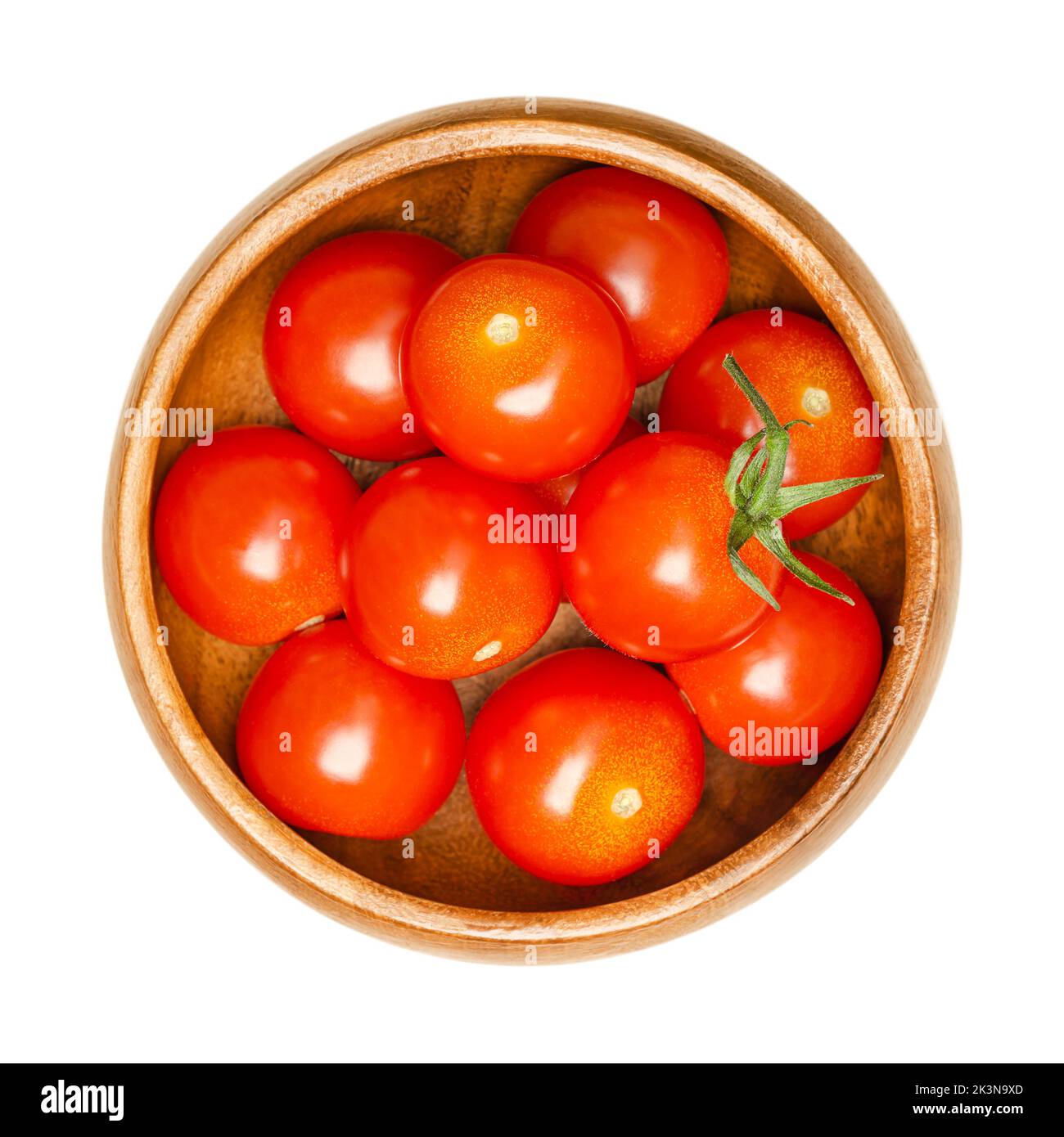 Cherry tomatoes, in a wooden bowl. Fresh and ripe type of red, small and round cocktail tomatoes, Solanum lycopersicum var. cerasiforme. Stock Photo